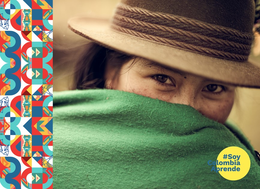 Foto de indigena con sombre y ruana verde