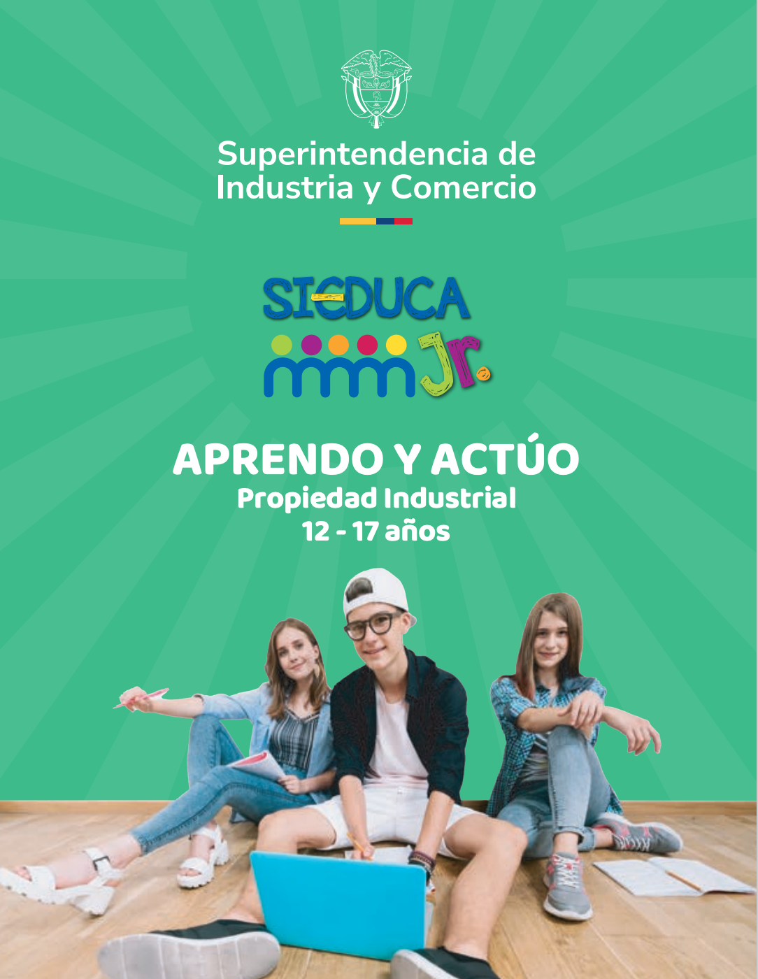 Imagen de tres jovenes sentados, dos mujeres y un hombre en el centro ente ellas, con un computador portátil frente a ellos.