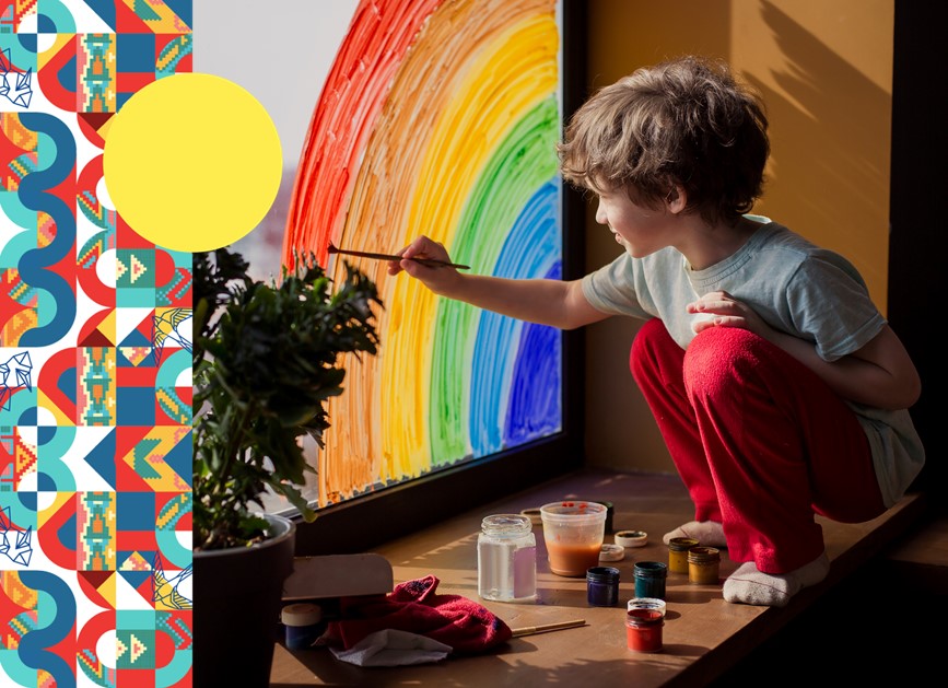 Foto de un niño arrodillado pintando un arco iris