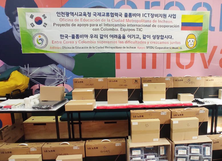 Cuarto con cajas y pancarta con información del Programa y la donación