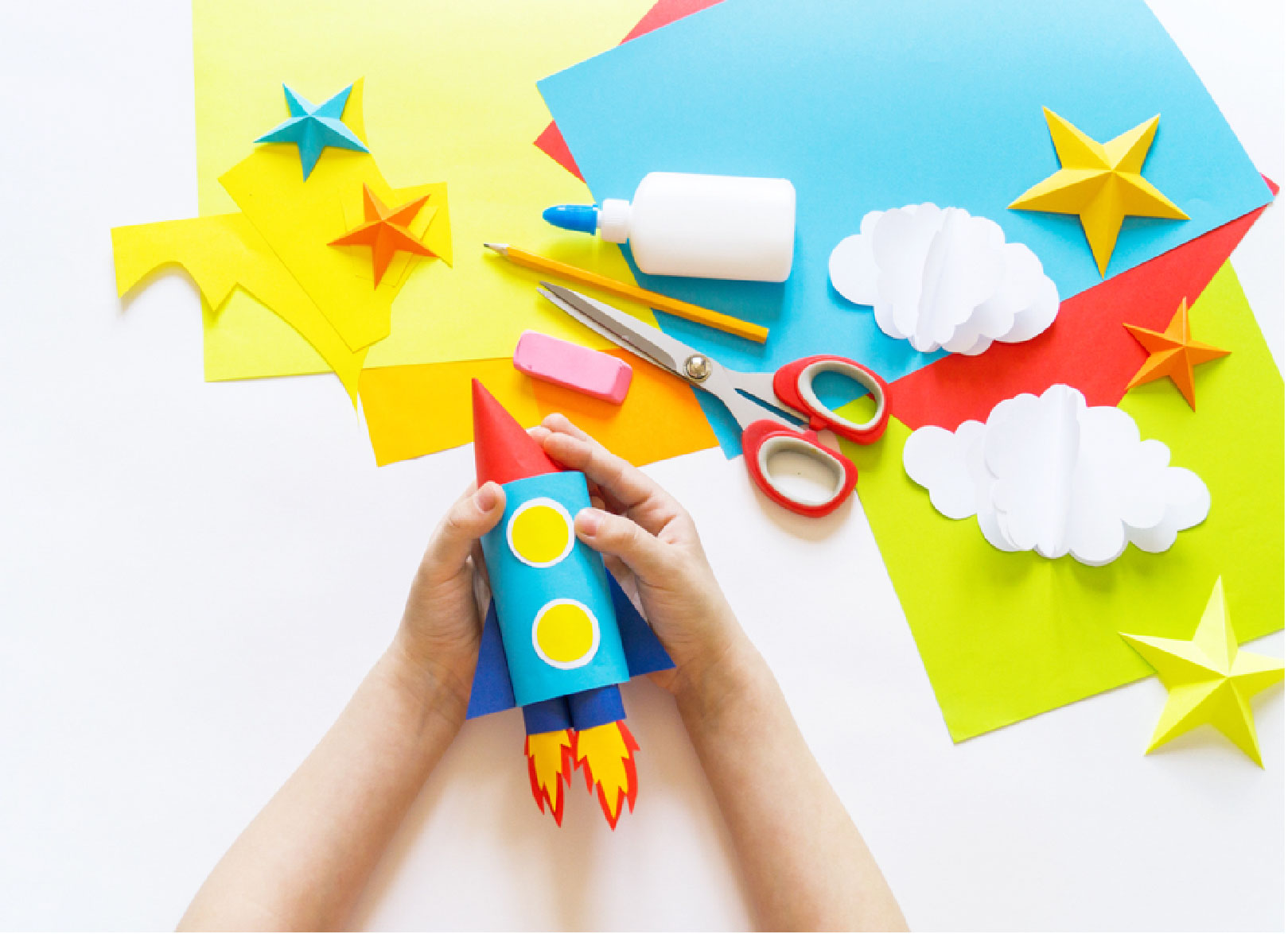 Fotografía de las manos de un niño haciendo manualidades con papel