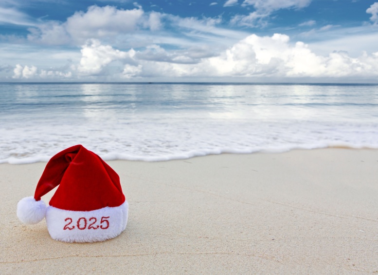 Fondo de Nuevo año 2025 con sombrero rojo de Santa en la playa del Caribe.