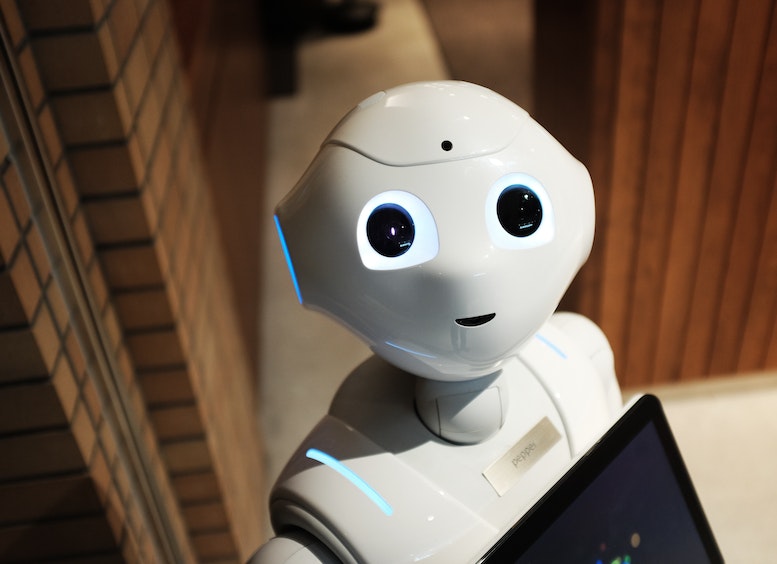 Foto de la cara de un robot con ojos negros y cara sonriente que mira a la cámara