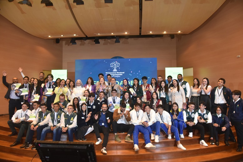 Gran grupo de estudiantes y docentes recibiendo el premio en auditorio