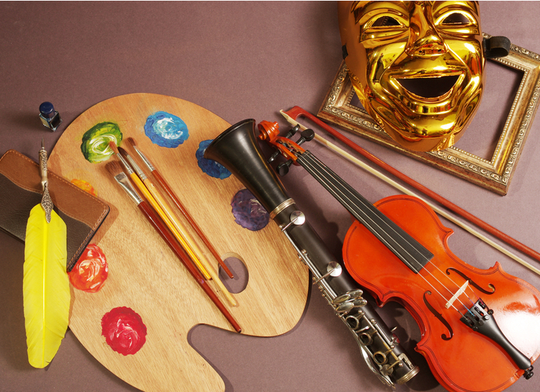 Fotografia de violín, paleta de arte y pinceles, pluma estilográfica, cuaderno, máscara de teatro.
