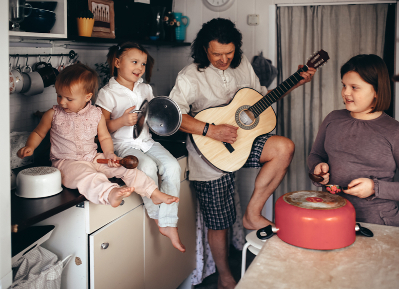 padre, madre y dos niños tocan instrumentos musicales y utensilios.
