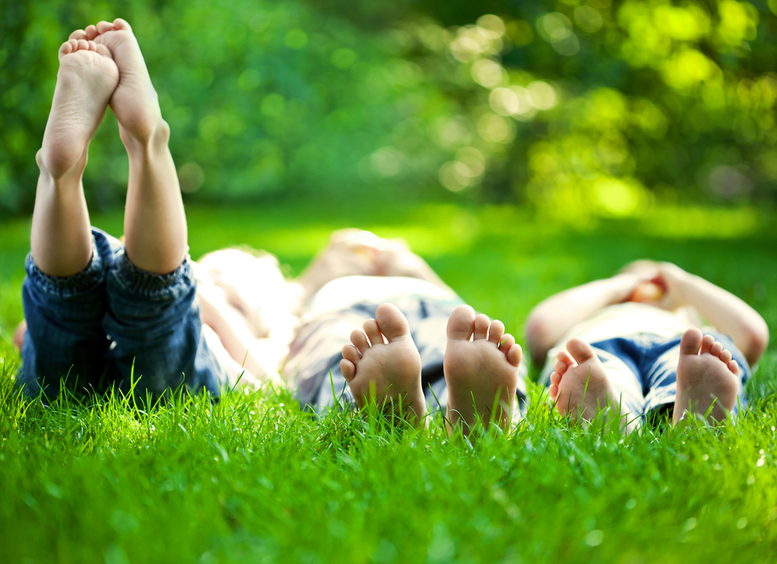 Grupo de niños felices tendidos sobre césped verde al aire libre en el parque