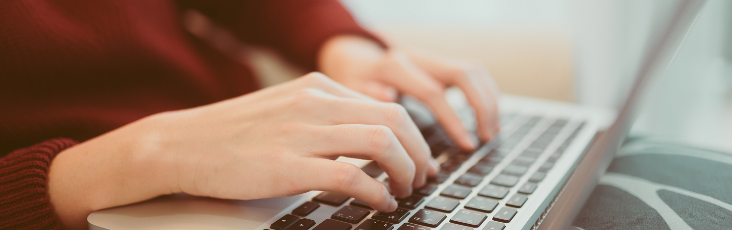 Mujer en un computador escribiendo