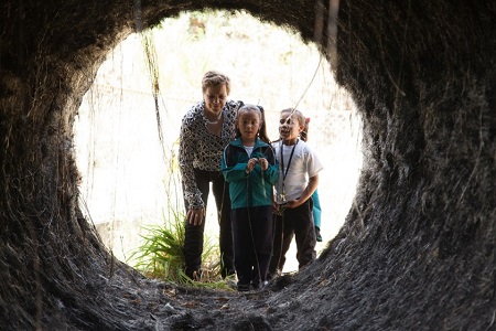 Foto de niñas con una mujer entrando en un tunel